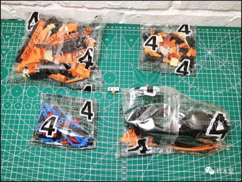 Các túi mảnh ghép số 4 của Xe đua McLaren P1 YC-QC004, với các chi tiết màu cam và đen đặc trưng, mang lại trải nghiệm lắp ráp chân thực cho bé trai 6 tuổi.