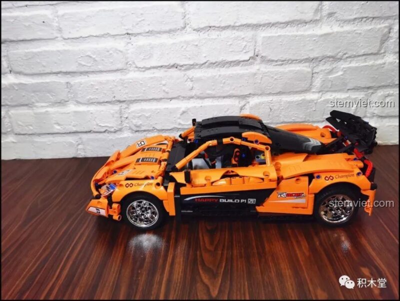 Mô hình Siêu xe McLaren P1 Happy Build đã hoàn thành, góc 3/4 phía trước bên phải, với các đường nét thể thao và bánh xe mạ chrome nổi bật, là đồ chơi mô hình chất lượng cao.