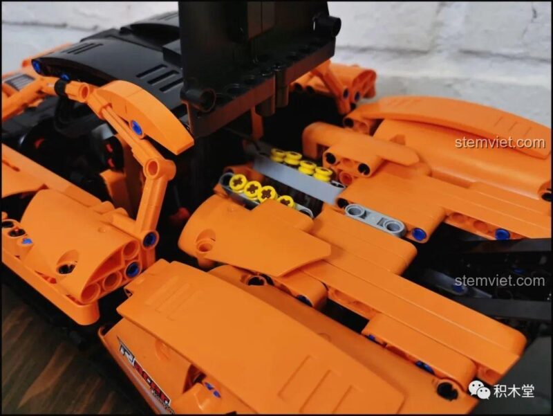Chi tiết bánh xe và thân xe bên hông của Bộ lắp ghép Happy Build QC004, nổi bật với logo Champion và các đường nét khí động học, tăng tính thẩm mỹ cho mô hình.