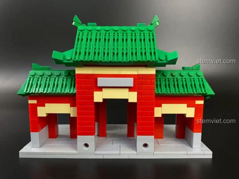 Ảnh chụp chính diện đồ chơi mô hình Cổng Chấp Tín Jimuquanzi JMQZ101, thể hiện chi tiết kiến trúc mái ngói xanh và tường đỏ.
