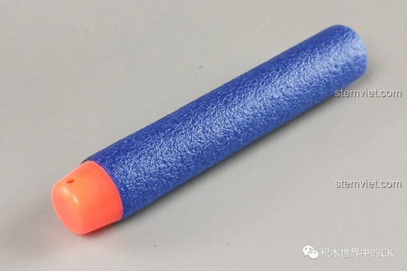 Cận cảnh phần tay cầm của đồ chơi mô hình súng Qman 6005, làm từ các mảnh ghép màu nâu.