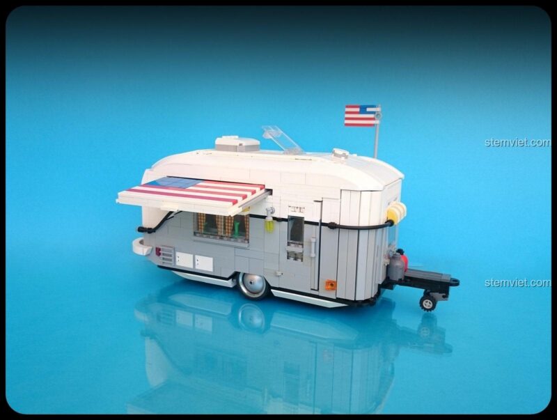 Cận cảnh xe moóc cắm trại từ bộ xếp hình Rebrickable 22102, thiết kế cổ điển, màu trắng và xám tinh tế.