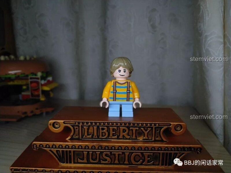Minifigure khách hàng nhí trong bộ đồ chơi Cửa hàng đồ ăn nhanh Sembo, mặc áo vàng và quần xanh.