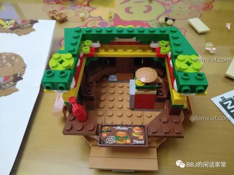 Nội thất bên trong của tiệm hamburger Sembo 601055 với quầy kệ và một chiếc bánh burger mẫu.