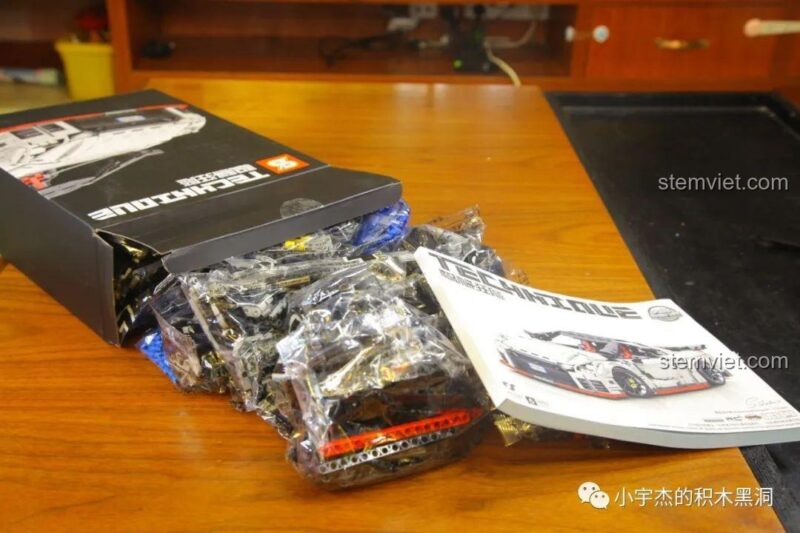 Hộp nhỏ của bộ lắp ghép Nissan GTR CaDA 8882 được mở ra, lộ các túi mảnh ghép và sách hướng dẫn, đồ chơi lắp ráp siêu xe GTR