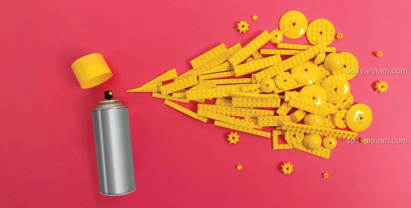 Sách LEGO Still Life của Chronicle ISBN9781452179629, hình ảnh bình sơn xịt tạo ra "vệt sơn" bằng gạch LEGO® màu vàng, thể hiện sự sáng tạo và nghệ thuật sắp đặt LEGO.