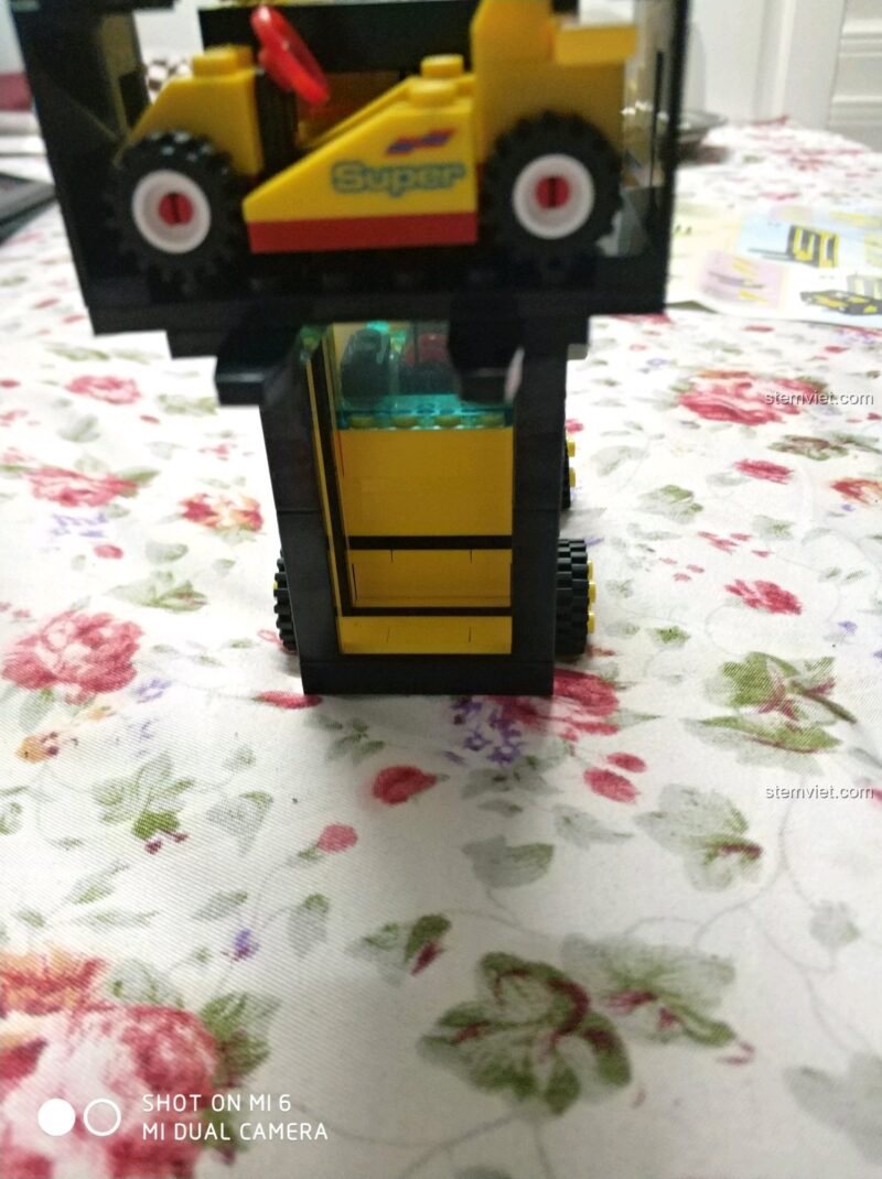 Bộ lắp ghép 493 Xe Nâng Hàng Kèm Xe Đua, xe nâng hàng với minifigure đang điều khiển, thể hiện khả năng nhập vai
