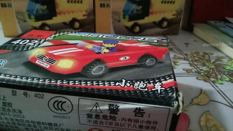 Ảnh chụp cận cảnh hộp đồ chơi mô hình 402, mô tả chiếc xe đua màu đỏ với tay đua, phù hợp cho bé trai.
