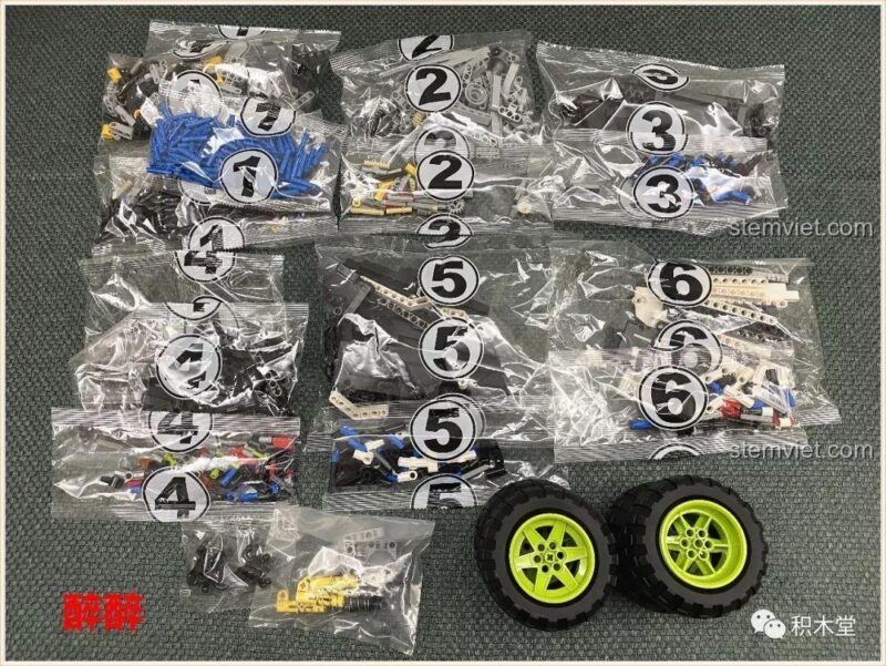 Các túi chi tiết và bánh xe lớn của bộ lắp ghép Happy Build 1211 Xe Tải Địa Hình Baja Monster Energy, sẵn sàng cho bé trai lắp ráp.