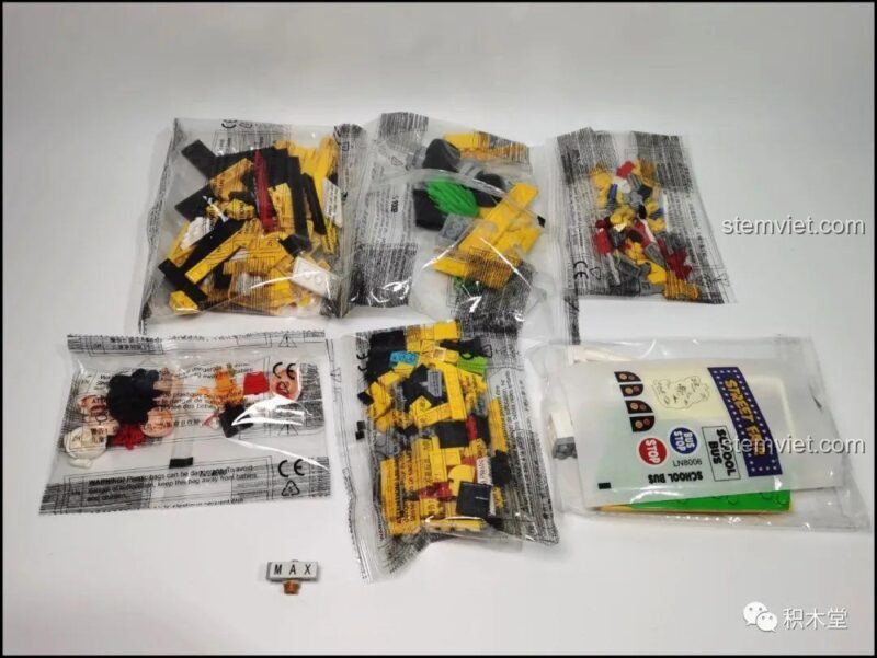 Bên trong hộp bộ lắp ghép LiNooS LN8006 Snoopy Hội Chợ Đường Phố và Xe Buýt Trường Học với các túi mảnh ghép được đóng gói cẩn thận