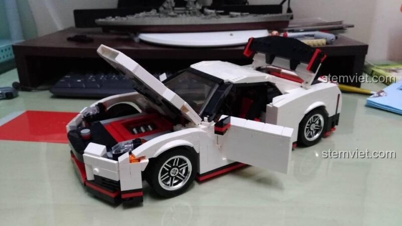 Mô hình Nissan GTR Nismo 13104 với các chi tiết cửa, capo, cốp sau mở được, cho thấy nội thất và động cơ bên trong.