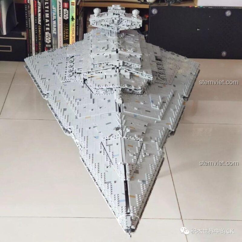Mô hình Mould King 13135 Tàu khu trục Ngôi sao Hoàng gia Monarch trên sàn nhà, so sánh kích thước với sách