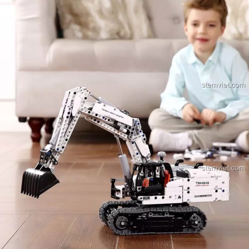Bé trai đang hào hứng chơi với mô hình Máy xúc công trình ONEBOT GCWJJ01IQI đã lắp xong. Món quà tuyệt vời cho con trai 8 tuổi.