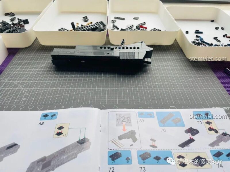 Mô hình súng lục M1911 PanlosBrick 670007 đặt cạnh hộp, thể hiện sự chân thực của đồ chơi lắp ráp