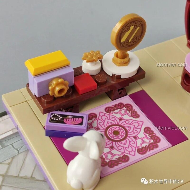 Góc nhìn khác của bàn trà nhỏ và phụ kiện trong bộ xếp hình QMAN 33013, làm nổi bật chi tiết thảm trải sàn.