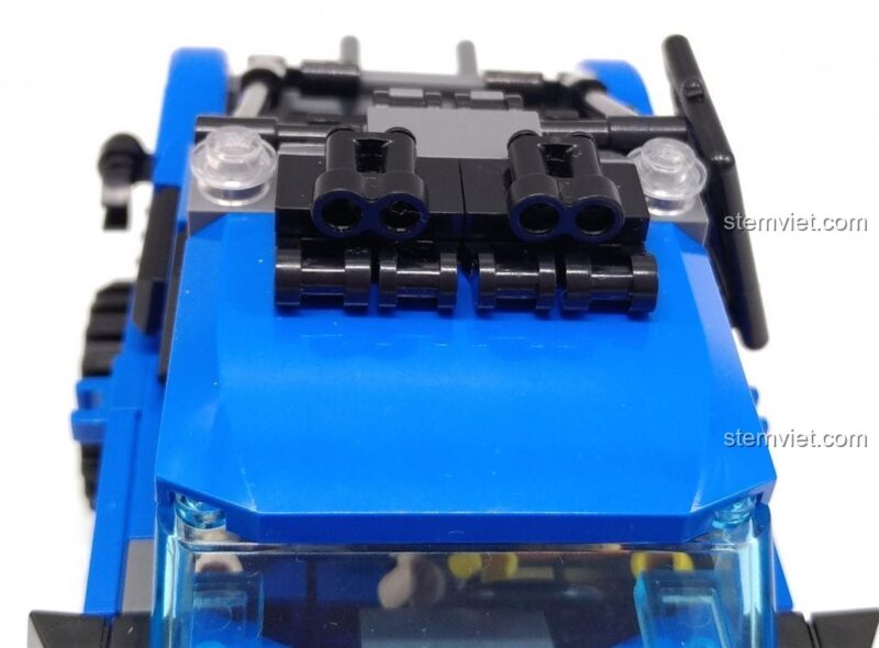 Đồ chơi mô hình 4803, bộ lắp ghép Khủng long Robot. Nội thất của mô hình xe bán tải màu xanh dương, với vô lăng và ghế ngồi, cho thấy độ chi tiết và khả năng lắp ráp tinh xảo của bộ đồ chơi lắp ráp QMAN 4803.