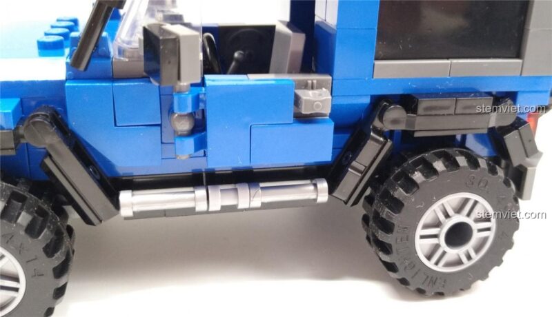 Bộ lắp ghép Khủng long Robot, đồ chơi lắp ráp Xe Off-road. Cửa xe SUV địa hình màu xanh dương mở ra, cho thấy nội thất bên trong, thể hiện tính năng tương tác của bộ đồ chơi lắp ráp QMAN 4803, phù hợp cho bé trai 6 tuổi.