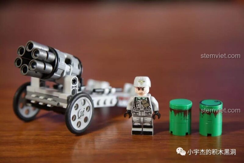 Minifigure lính Đức trong bộ đồ chơi SEMBO 101106 đứng cạnh khẩu pháo, mặc quân phục xám và đội mũ trắng.