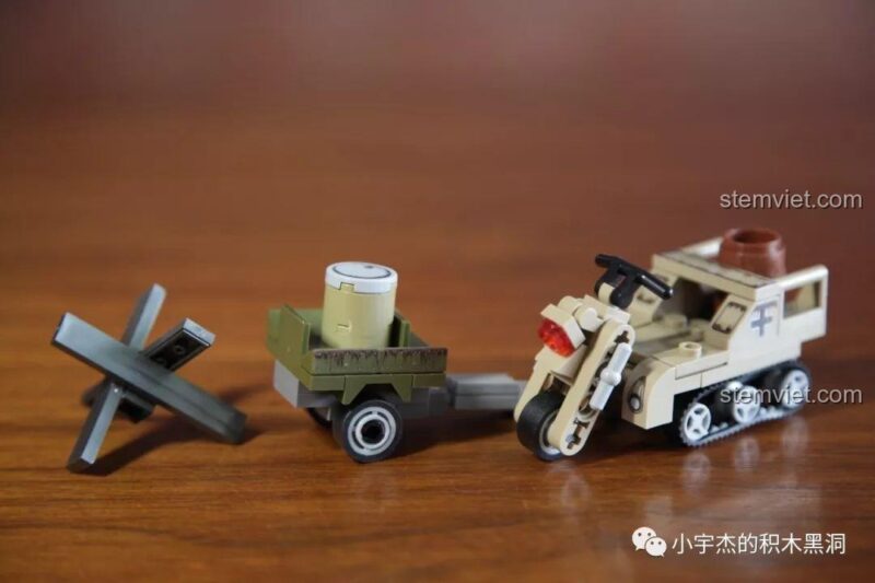 Mô hình Xe bán xích quân sự SEMBO 101107 hoàn chỉnh, kéo theo rơ-moóc và có một chướng ngại vật chống tăng.