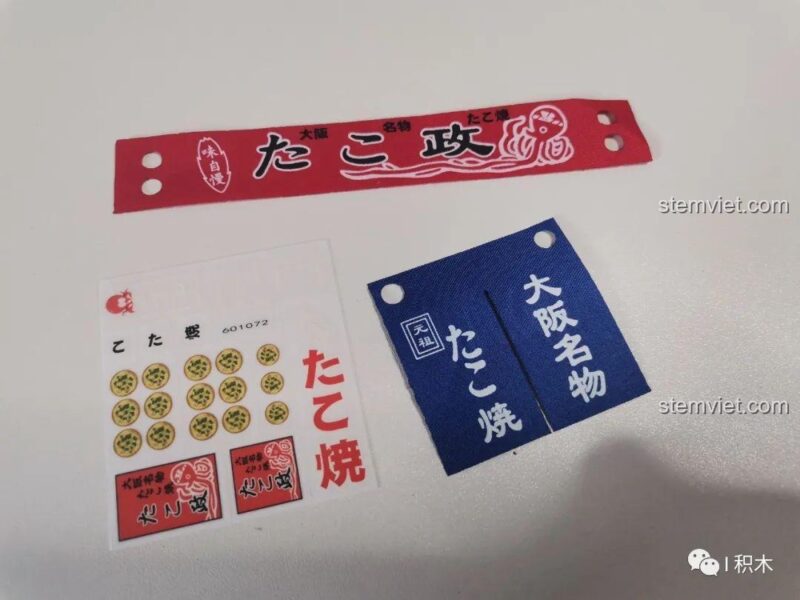 Tấm decal và vải in chi tiết của bộ đồ chơi mô hình Cửa hàng Takoyaki SEMBO 601072, tăng thêm tính chân thực cho mô hình.