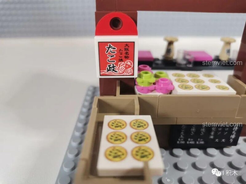 Mô hình Cửa hàng Takoyaki SEMBO 601072 đang trong quá trình lắp ráp, thể hiện cấu trúc bên trong và các chi tiết ban đầu.