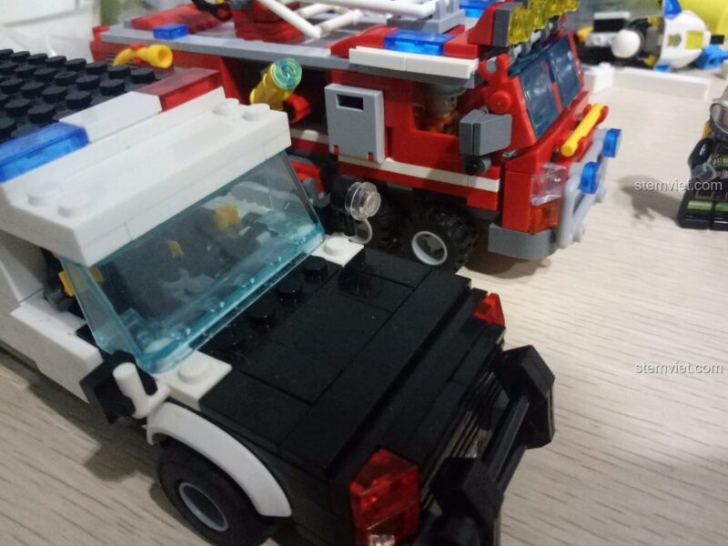 So sánh kích thước xe cứu hỏa SEMBO 603034 với một mô hình xe cảnh sát khác, cho thấy tỉ lệ của đồ chơi mô hình