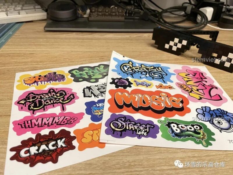 Các tấm sticker graffiti đi kèm bộ lắp ghép Thug Life Sembo 707901C, cho phép bé trai 6 tuổi tùy chỉnh giá đỡ, tăng tính sáng tạo.