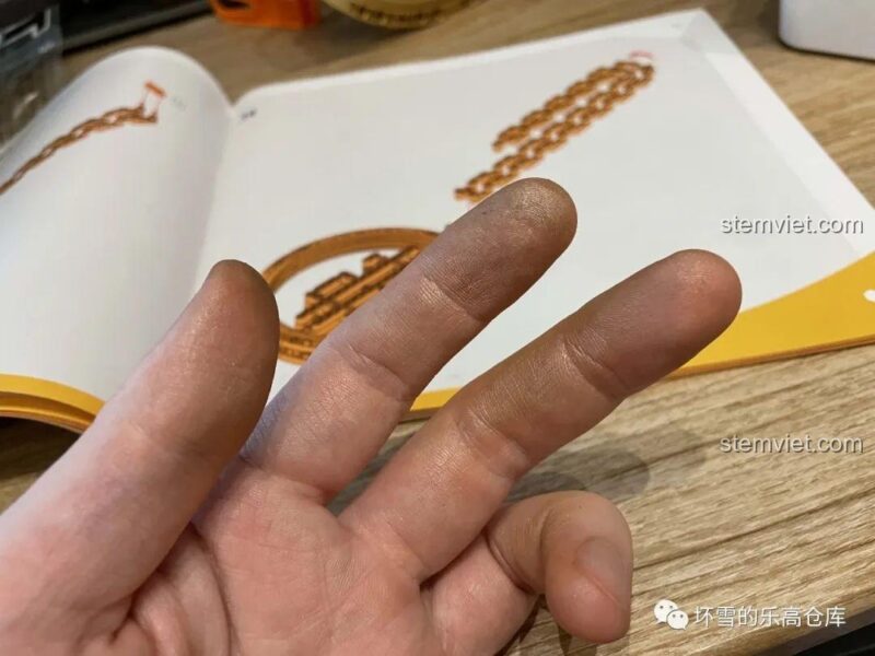 Ảnh tay người dùng bị dính bụi vàng từ mảnh ghép của bộ đồ chơi Thug Life Sembo 707901C, minh họa chất liệu mạ điện.
