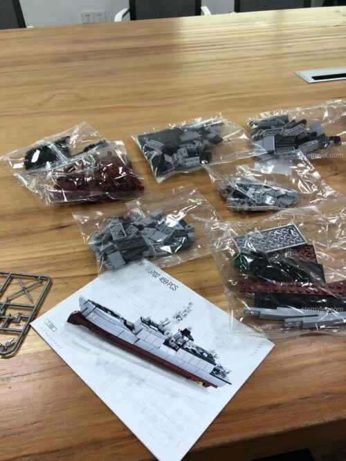 Mở hộp bộ lắp ráp tàu chiến Sluban M38-B0702 với các túi chi tiết được phân loại và sách hướng dẫn lắp ráp chi tiết.