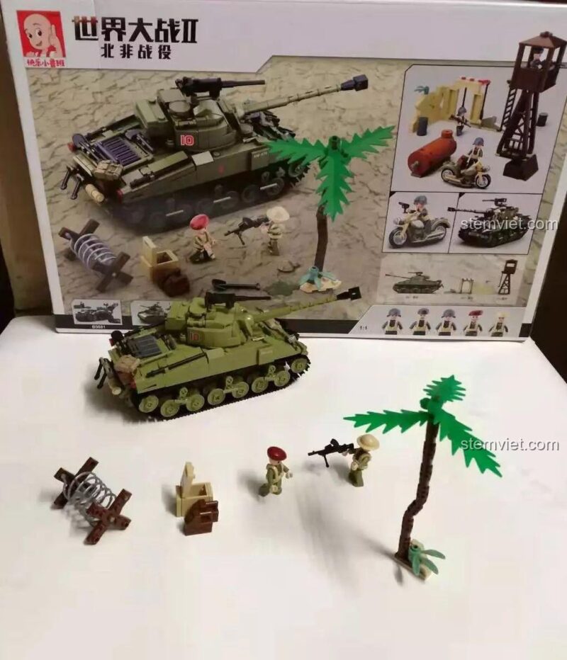 Bộ đồ chơi Sluban, cảnh quan chiến trường với hộp sản phẩm làm nền, tạo cảm giác chân thực.