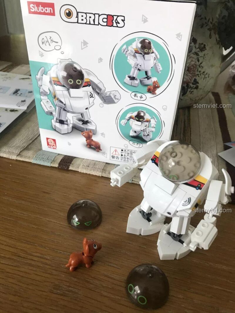 Robot Q-Bricks M38-B0761E cùng chó robot và các đầu thay thế biểu cảm, sẵn sàng cho bé trai 6 tuổi khám phá.