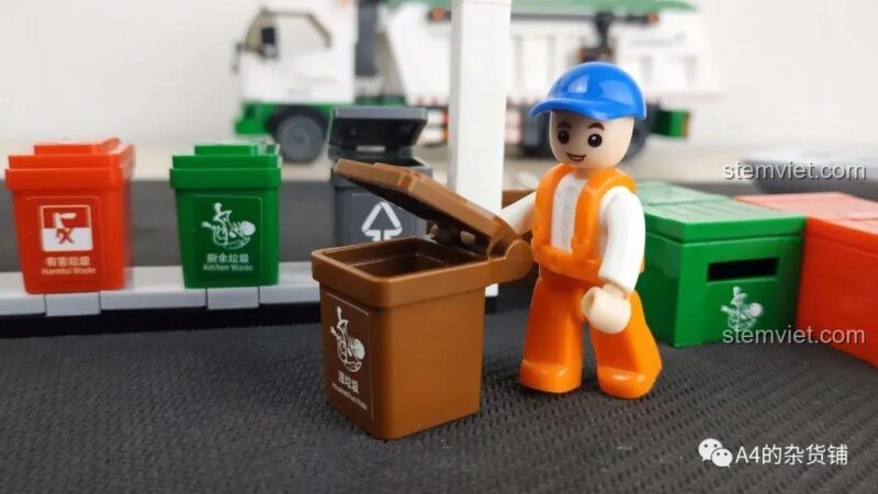 Minifigure công nhân vệ sinh đang thao tác với thùng rác, một cảnh chơi nhập vai với bộ Sluban M38B0780.