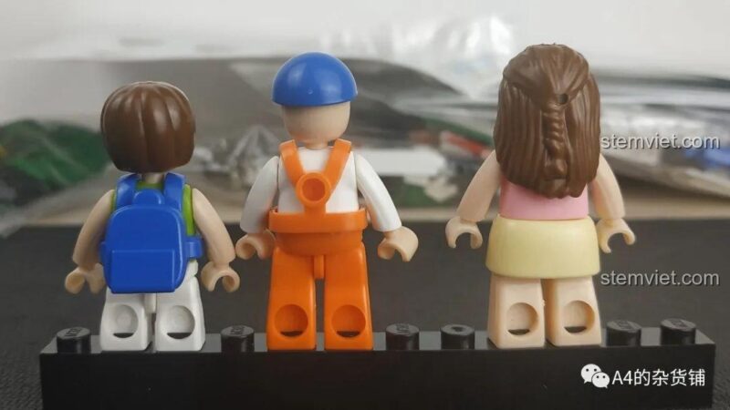 Mặt sau của 3 minifigures trong bộ Xe Chở Rác Đô Thị 780, thể hiện chi tiết tóc và ba lô.