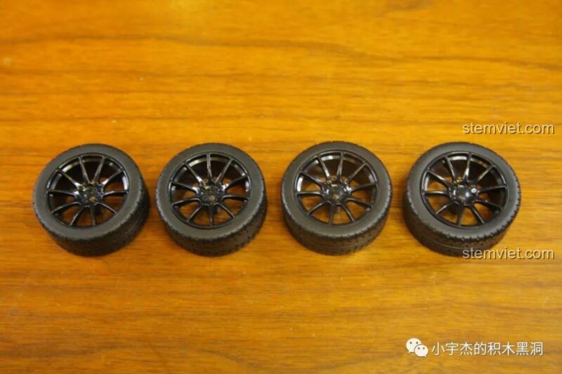 Bánh xe và lốp xe của bộ lắp ghép Ferrari 488 GTE JiaZhi 8613, với vành xe màu đen thể thao.