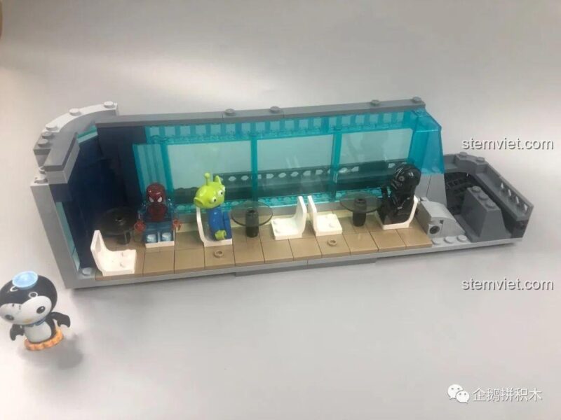 Khu vực tiếp khách phụ tầng 2 của Tòa Tháp Avengers Taige Blocks 55120, với ghế ngồi và nhân vật ngoài hành tinh, tạo nên không gian sống động cho đồ chơi mô hình.
