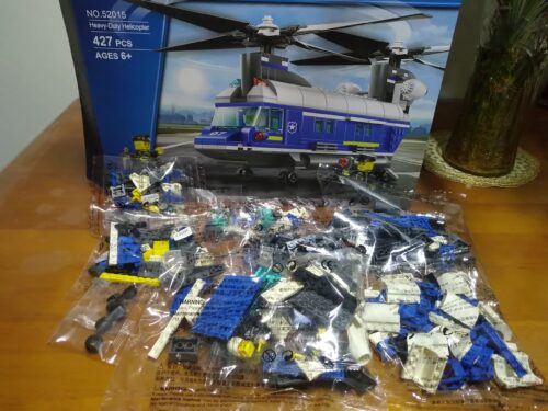 Ảnh chụp bộ lắp ráp Trực thăng Vận tải Cảnh sát WANGE 52015 với các túi chi tiết chưa bóc và vỏ hộp phía sau, dành cho bé trai 6 tuổi.