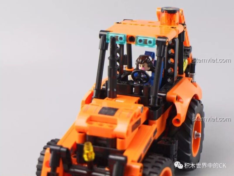Một minifigure được đặt vào cabin của Xe Xúc Lật Kèm Gầu Đào để so sánh kích thước.