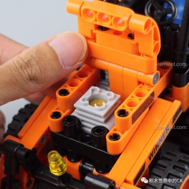 Tính năng mở nắp capo của Winner 7057 Xe Xúc Đào Đa Năng, để lộ động cơ giả bên trong.