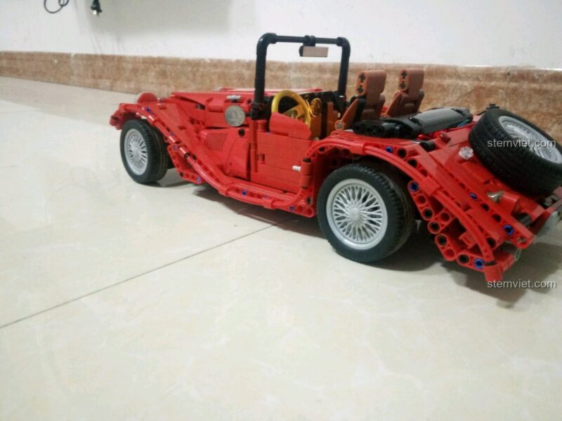 Đồ chơi mô hình Winner 7062 Xe Mui Trần Cổ Điển Màu Đỏ nhìn từ góc sau, thể hiện chi tiết thiết kế và bánh xe dự phòng, dành cho bé trai 6 tuổi, chất lượng cao.