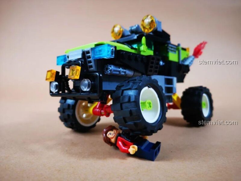 Hệ thống giảm xóc của xe Jeep quân sự màu xanh lá hoạt động, thể hiện tính năng đặc biệt của bộ đồ chơi WOMA C0195 Trở Lại Chiến Trường: Xâm Nhập Sâu Vào Địch.