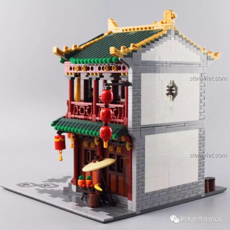 Góc nhìn từ bên hông của mô hình Trà Quán, thể hiện kiến trúc tường trắng ngói xanh hài hòa.
