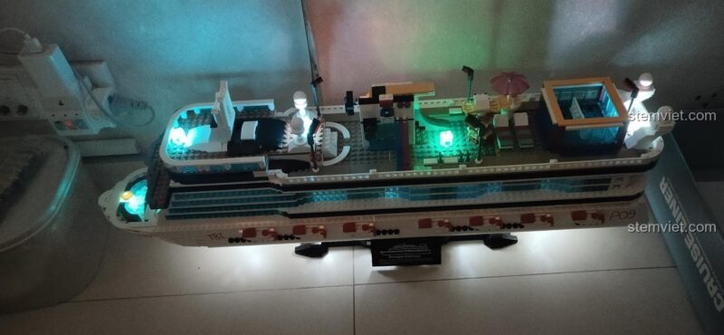 Ảnh review người dùng chụp mô hình Du thuyền Norwegian Breakaway QL1807 Zhe Gao với ánh sáng đèn LED xanh dương, tạo hiệu ứng đẹp mắt.