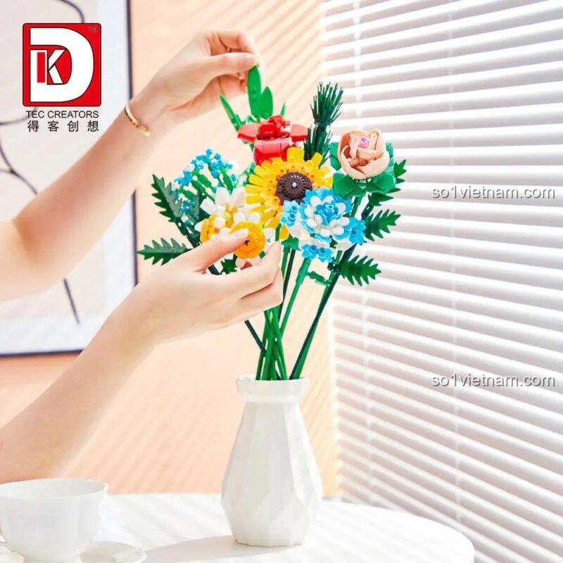 Bàn tay đang lắp ráp chi tiết hoa cho bó hoa lắp ghép DK 3027, thể hiện sự tỉ mỉ và sáng tạo, đồ chơi giáo dục cho bé gái 8 tuổi