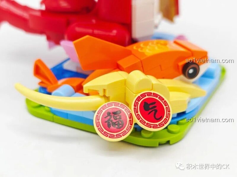 Lắp ráp phần đế của rồng xanh với các thỏi vàng và bao lì xì, thuộc bộ Keeppley K19910.