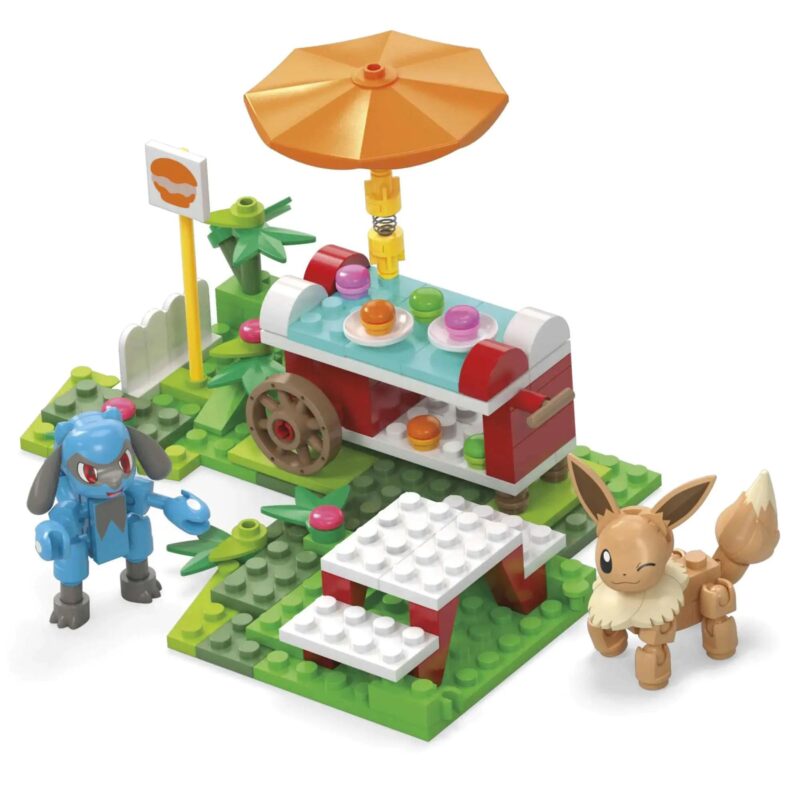 Bộ lắp ghép Mega Bloks Pokémon HDL80 với nhân vật Eevee và Riolu trong khung cảnh cắm trại, có xe đẩy đồ ăn và bàn ghế.