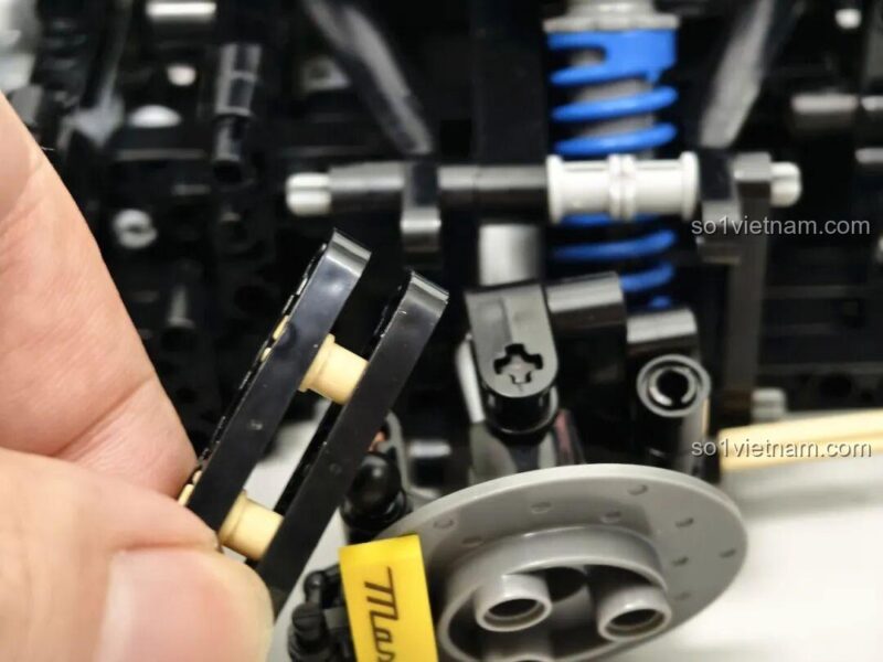 Chi tiết khung gầm bộ lắp ghép Reobrix 11010 Maserati GranTurismo, với các chốt màu xanh dương, thể hiện sự tỉ mỉ trong thiết kế.