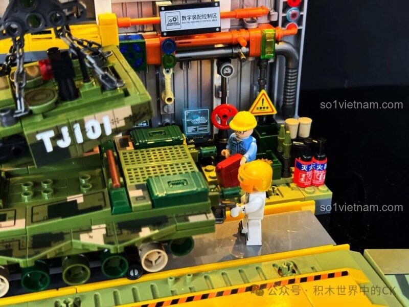 Cảnh minifigures đang lắp ráp xe tăng trong xưởng của bộ xếp hình 203189, thể hiện tính năng mô phỏng quy trình sản xuất, giá trị cao cho bé trai 8 tuổi