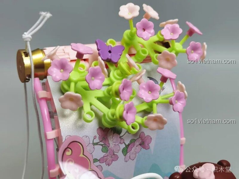 Những bông hoa đào màu hồng được tái hiện sinh động trên đỉnh bức tranh cuộn.